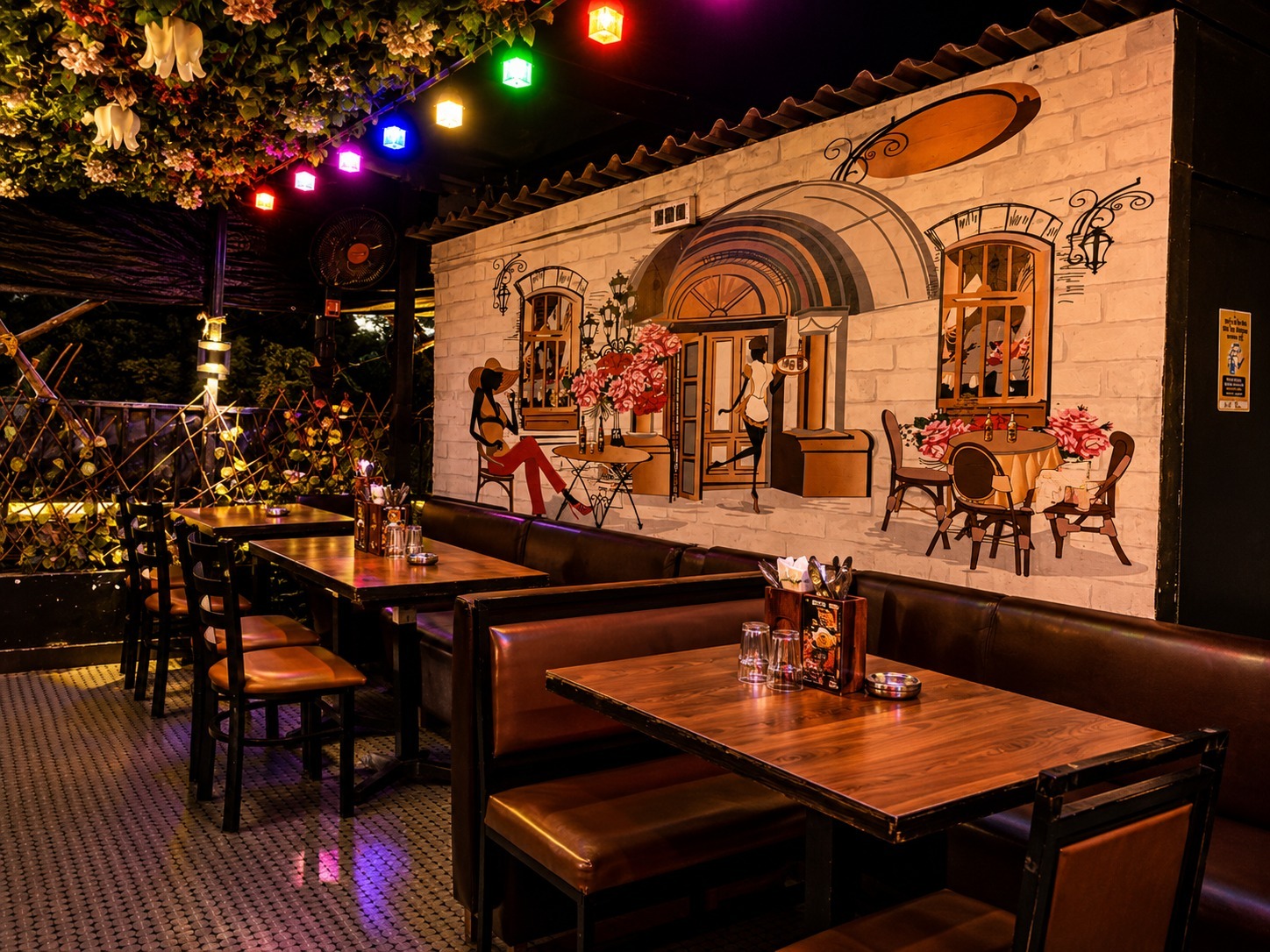 Intimate garden seating arrangement surrounded by potted greenery and flickering candlelight at Big Bull Cafe rooftop